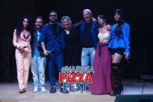 Artisti sul palco del Guardea Pizza Fest con il pubblico applaudenti